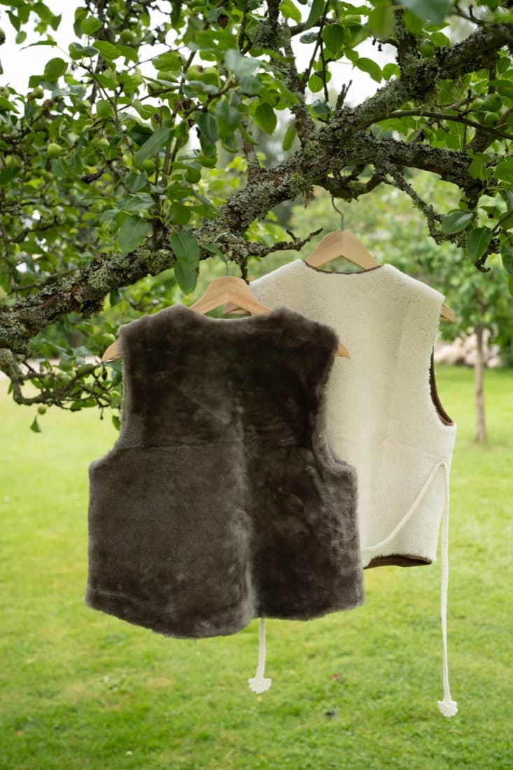 Grey and cream shearling vest hanging outdoors